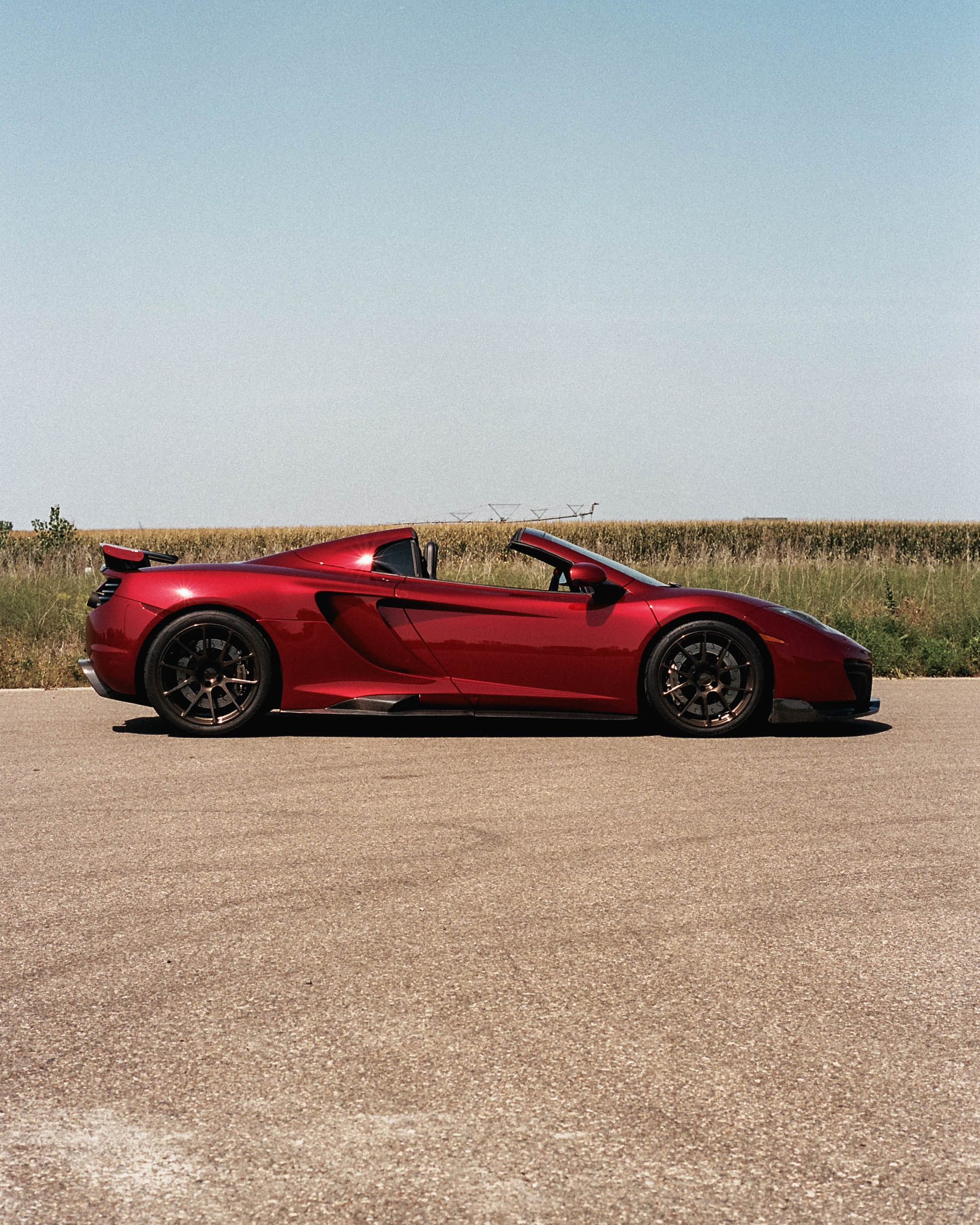 Red McLaren supercar side profile photographed by Alphpixels